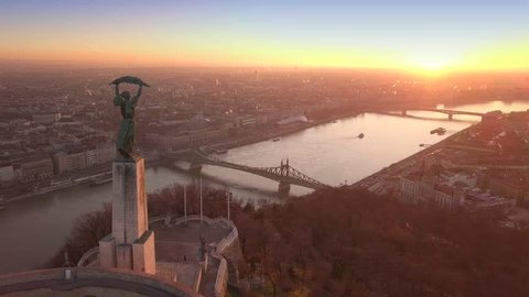 Budapest, Hungary - 4K aerial footage at sunrise of drone flying over of Statue of Liberty towards Liberty Bridge and River Danube