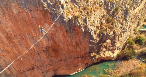 1 Brave Man Slacklining , highlining above a big canyon in Chulilla , Spain . Nature Adventure and leisure sport . Mountain Balance Extreme Hiker Walking Happy, 4k aerial cinematic footage