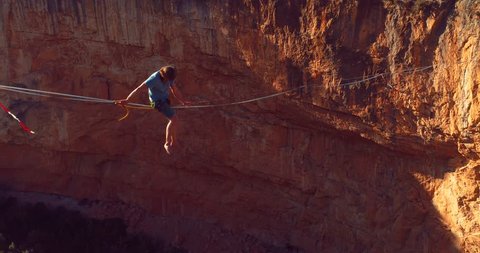 Brave young Man Slacklining , highlining above a big canyon in Chulilla , Spain . Nature Adventure and leisure sport . Mountain Balance Extreme Hiker Walking Happy, 4k aerial cinematic footage