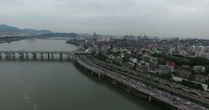 SEOUL, SOUTH KOREA – JULY 216 : Aerial shot over Han River on a cloudy day with traffic and cityscape in view