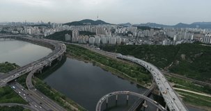 SEOUL, SOUTH KOREA – JULY 216 : Aerial shot over Han River on a cloudy day with traffic and bridge in view