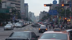 SEOUL, SOUTH KOREA – JULY 216 : Video shot of Seoul city centre traffic on a cloudy day with cars and peopl crossing street in view