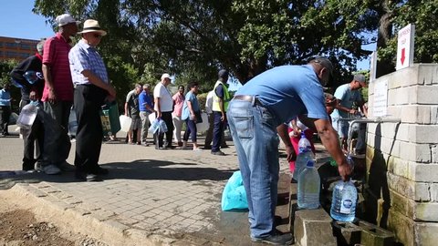 Cape Town / South Africa - January 25,  2018 : People waiting in long line to get drinking water with water bottles at Newlands natural spring in the drought in Cape Town South Africa