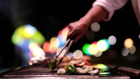 chef cook the bbq seafood in near beach for dinner party With bokeh backgroundの動画素材