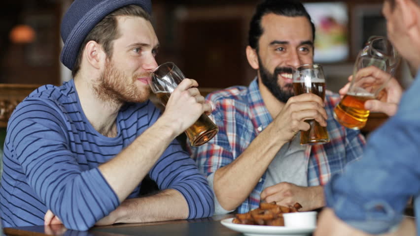People, leisure, friendship and celebration concept - happy male friends drinking beer, eating bread snack and clinking glasses at bar or pub | Shutterstock HD Video #10067894