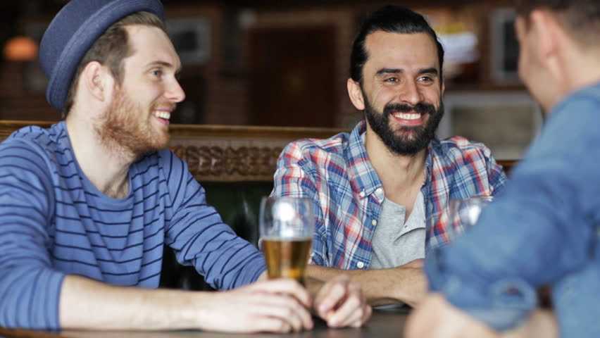 People, men, leisure, friendship and communication concept - happy male friends drinking beer at bar or pub | Shutterstock HD Video #10067918