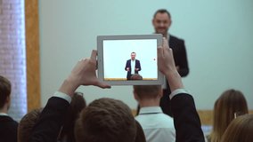 group of students studying in college in classroom listening teacher using tablet computer. Man making video by tablet business people seminar conference meeting training coach speaker audience group  - Powered by Shutterstock - Get 15% off with code: PIKWIZARD15