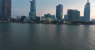 HO CHI MINH CITY, VIETNAM – MAY, 2016 : Aerial shot over Saigon river at sunset with Ho Chi Minh cityscape and tall buildings in view