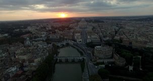 ROME, ITALY – OCTOBER 2015 : Aerial shot over river Tiber at a beautiful sunset with Castel St Angelo, Vatican city and cityscape in view
