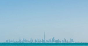DUBAI, UAE – MARCH 2016 : Timelapse from a distance of Dubai skyline on a sunny day with ocean in view