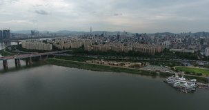 SEOUL, SOUTH KOREA – JULY 216 : Aerial shot over Han River on a cloudy day with central Seoul cityscape, traffic and landscape in view