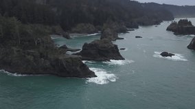 Aerial view of the beautiful rocky ocean shore at the West Coast during a cloudy winter morning. Taken in Oregon Coast, North America.