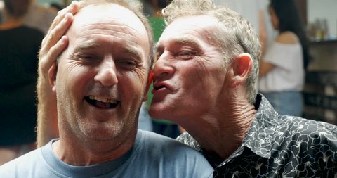 Profile of two affectionate men and joking with each other at a party or bar pub Stockvideo