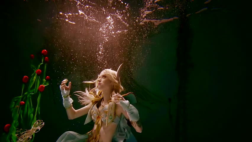 young girl in the elf costume is kept under water in the darkness illuminates the light. role play. - Powered by Shutterstock - Get 15% off with code: PIKWIZARD15