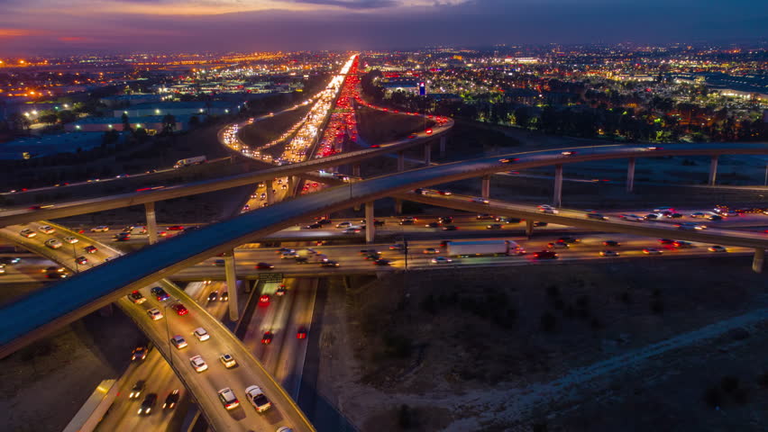 Urban aerial drone time lapse in motion or hyperlapse at night flying along an interstate with traffic showing the on and off ramp circles. | Shutterstock HD Video #1006816045