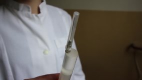 Nurse's hands getting air bubbles out of a syringe before  injection, with close up of the syrgine and blured focus in the end of the video, hd