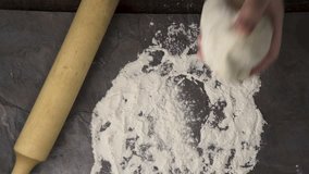 Dough and flour, roll on a gray table. Video