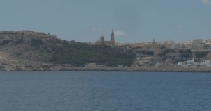 MALTA – AUGUST 2016 : Video shot from a boat on a sunny day with Gozo landscape and harbor in view