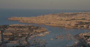 MALTA – AUGUST 2016 : Aerial shot over Sliema cityscape during a beautiful sunset with Valletta harbor and Manoel Island in view