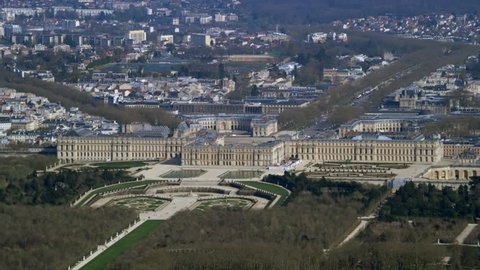 4K Aerial view above the palace of Versailles with landscaped gardens & the surrounding area