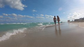 Young couple on vacation running on a sandy beach