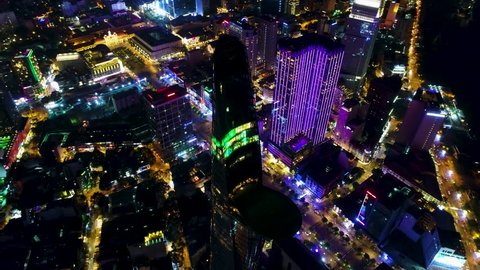 Aerial: A night time shot of Downtown Saigon (Ho Chi Minh City) business district. Featuring a slow revolve of an iconic feature within the Saigon city center.