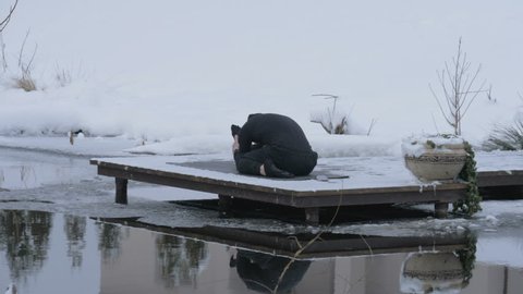 A man is meditating in nature in the winter. Yoga.