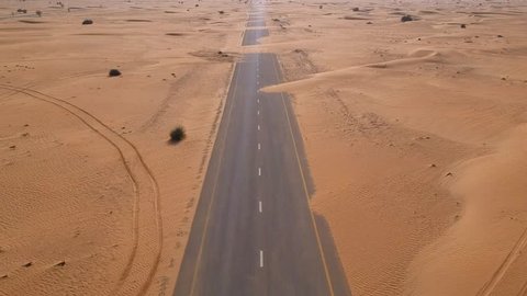Dubai Flying with drone forward blocked road with sands in desert with drone footage Arabian desert in Dubai, United Arab Emirates, UAE.