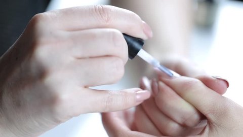 Women paints nails.Manicure Nail Art close up. Beautiful Nail Art Manicure. Nail designs with decoration.Manicure nail paint.