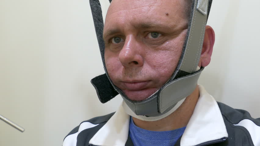 Man with head in physiotherapy traction machine