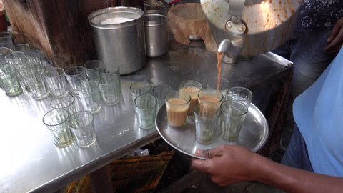 MUMBAI, INDIA - NOV 24: Indian masala chai tea being poured into glasses at stall on November 24, 2017 in Mumbai, India 