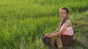 4k video of happy farmer woman sitting in green rice filed, Thailand