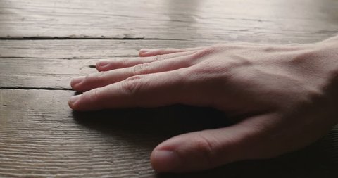 Close-up of a hand touching a wooden piece of furniture to feel its consistency and the precious material with which it was built. Concept of: love for nature, wood.