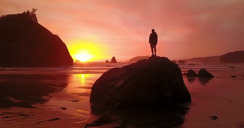 Aerial: Active Man on Rock Admiring Amazing Sunset