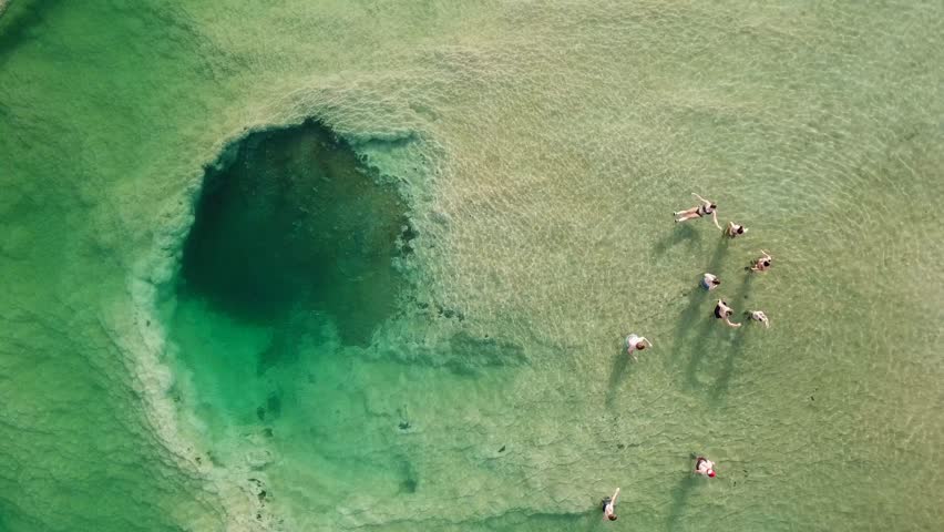Top down aerial footage of people floating in the salty water of the Dead Sea, Israel.