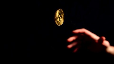 Slow motion Bitcoin being coin tossed in the air with black background, gold cryptocurrency spinning BTC