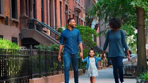 Young black family walking in a Brooklyn street