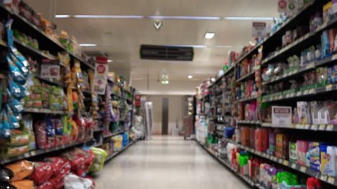 Supermarket Aisle Slow Motion. Slow motion of a shopping cart in the supermarket aisle with products and people