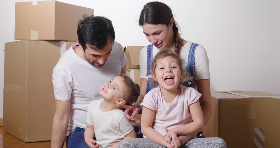 Portrait of a beautiful happy and smiling family holding the house shaped meter just arrived in the new house to start a new path together. Concept of: love, family, home. | Shutterstock HD Video #1006877881