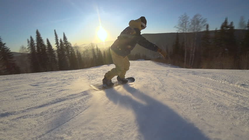 Active man snowboarder riding on slope. Snowboarding closeup.