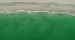 Aerial drone close up views of sandy beach with clear turquoise waters