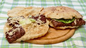 Juicy hamburger of pork and beef meat with mayonnaise and lettuce, 4k Video Clip