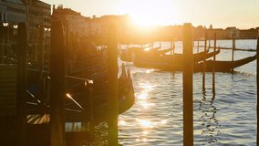 Moored gondolas on the background of sunrise. Venice, Italy.