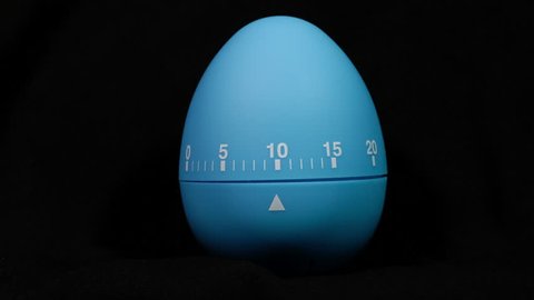 Kitchen egg timer countdown to zero time lapse on a black background.