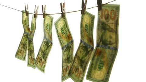 Dollar banknotes hang on a rope with clothespins. The concept of dirty money. 