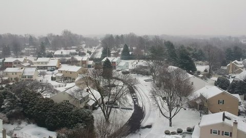 Aerial view of a suburban neighborhood during a snow storm 
