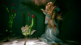 Unbelievable female elf with beautiful red tulips floating underwater. She is posing holding flowers. - Powered by Shutterstock - Get 15% off with code: PIKWIZARD15