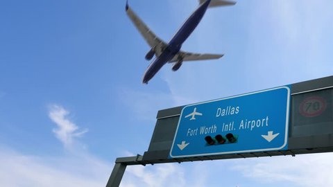airplane flying over dallas airport signboard