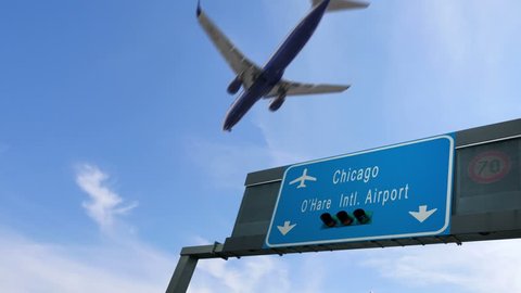 airplane flying over chicago airport signboard