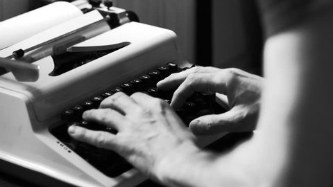 Hands typing a film script or a book on a vintage typewriter, 4k black and white video 